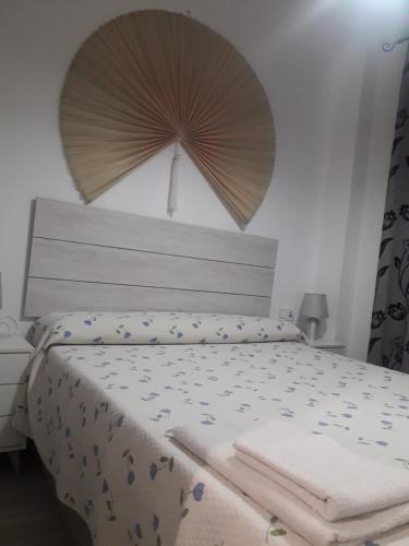 梅利利亚Apartamento Playa Blanca的一间卧室配有一张带遮阳伞的床铺。