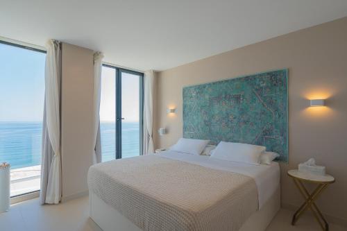 多列毛利诺斯Seaside Tranquility and Urban Luxury - Stylish Duplex in Torremolinos w jacuzzi的一间卧室设有一张大床和大窗户