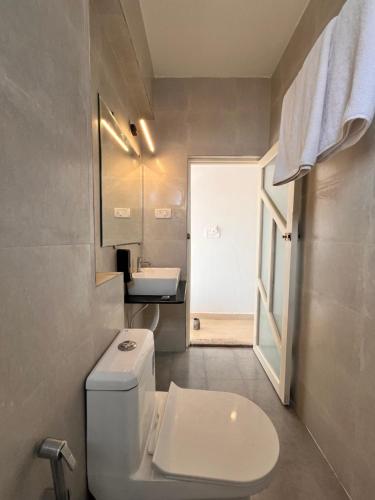 巴加Baga beach front的浴室配有白色卫生间和盥洗盆。