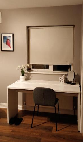 卡洛En-Suite room in Carlow Town的一张带椅子的白色书桌和一个窗口