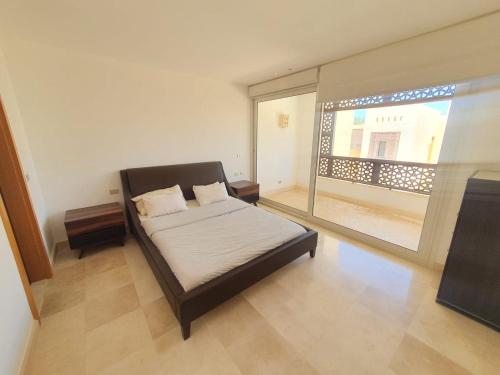 赫尔格达Nayah Stays, Beautiful 3-bedroom vacation home with lovely pool的一间卧室设有一张床和一个大窗户