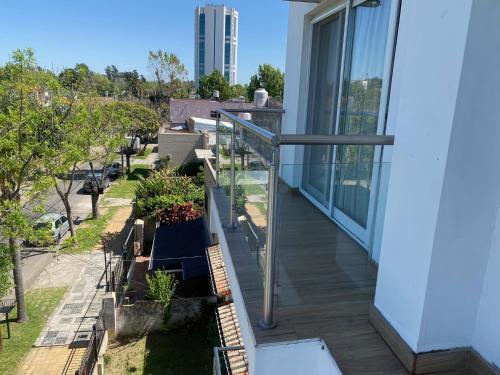 蒂格雷Tigre Urban Suites的阳台上设有玻璃栏杆和植物