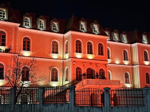普里什蒂纳Hostel Prishtina Backpackers的一座橙色的大建筑,晚上有灯