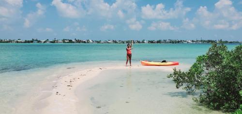 基韦斯特Bonnethead Key Floating Campground and Private Island的站在船旁海滩上的女人