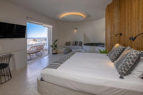 提诺斯Onar Hotel & Suites的一间带大床的卧室和一个阳台