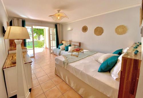 圣安尼Studios Barbadine - Resorts Flats的一间卧室配有两张带蓝色枕头和灯的床。