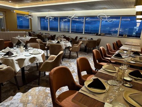 普雷兰Le Manoir du Roselier - Hôtel 3 étoiles的用餐室设有桌椅和窗户。