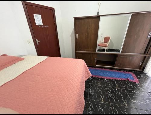 索里苏Pensão da Rose的一间卧室配有一张床和一张镜子内的椅子