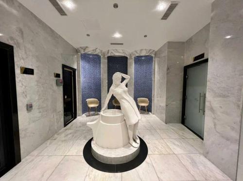 阿拉尼亚Serenity SPA ALL-IN apartment Luxury resort private beach的浴室内有一张雕塑,一个女人坐在浴缸上