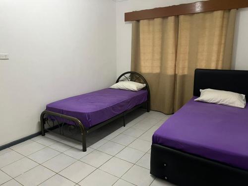 南迪Ziara Apartments的紫色床单的客房内的两张床