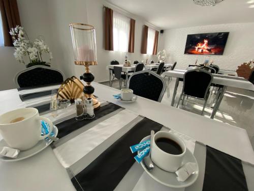 科沙林Rezydencja Myśliwska - Apartamenty的一间设有白色桌椅的用餐室