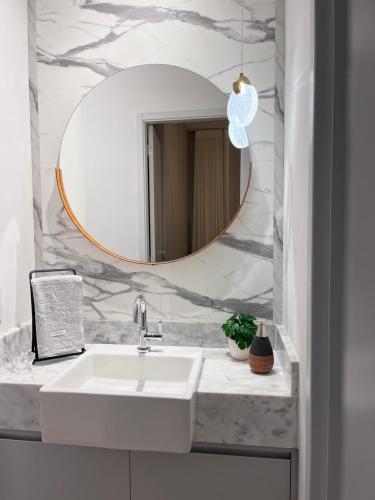 里贝朗普雷托Fiusa Dream 153的浴室设有白色水槽和镜子
