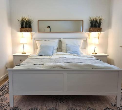 罗斯托克Familientraum auf 120 m2 in Rostock的卧室内的一张大白色床,配有两盏灯