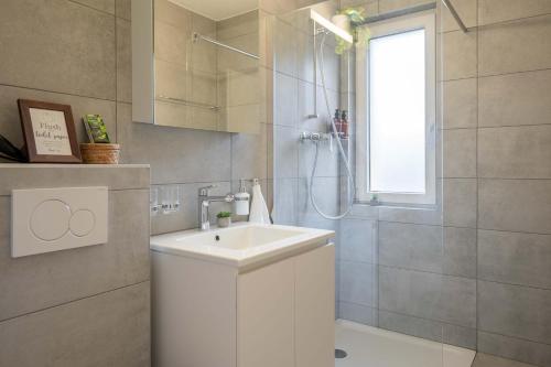 奥斯特蒙迪根Moderne Wohnung mit Parkplatz - Top Floor的浴室配有白色水槽和淋浴。