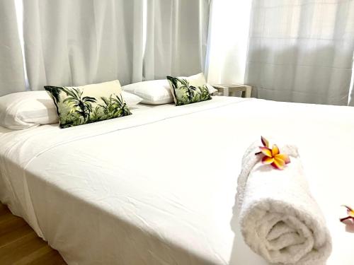 PaeaHeitiare lodge的一张白色的床,上面有一条毛巾