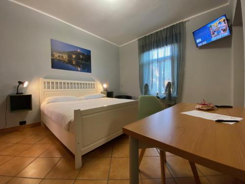 卡塞勒托瑞尼斯DOMUS Hotel的一间卧室配有一张床、一张桌子和一张桌子