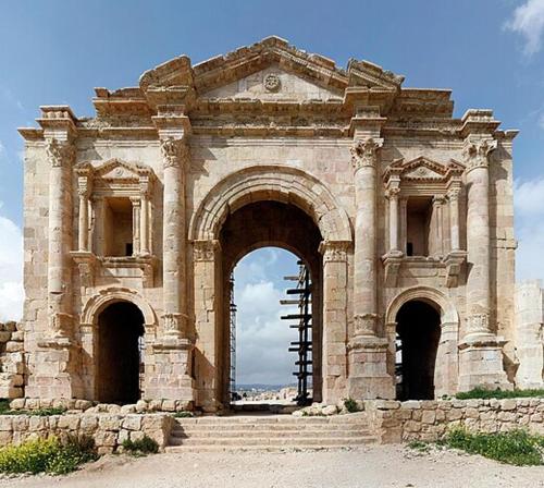 杰拉什Jerash Ruins Hotel的前方有楼梯的大型石头建筑