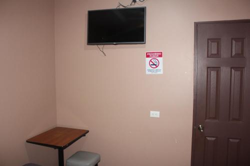 圣何塞Hotel Pecos Bill的墙上配有平面电视的房间