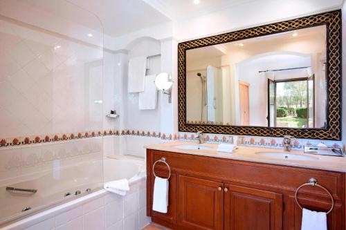 柳奇马约尔Marriott’s Club Son Antem的带浴缸、水槽和镜子的浴室