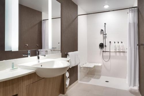 斯科茨SpringHill Suites by Marriott Phoenix Scottsdale的白色的浴室设有水槽和淋浴。