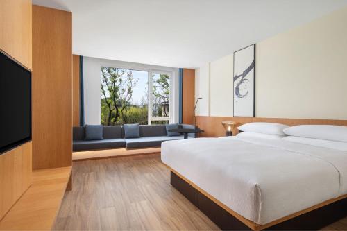 淳安杭州千岛湖万枫酒店­­的一间卧室配有一张床、一张沙发和一个窗口