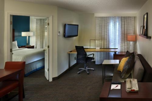 米斯蒂克神秘格罗顿公寓式酒店的配有一张床和一张书桌的酒店客房