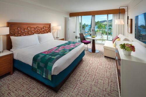 利胡埃万豪可爱岛海滩俱乐部酒店的酒店客房设有一张大床和一个阳台。