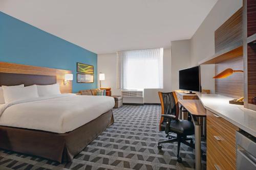 伍德布里奇TownePlace Suites by Marriott Potomac Mills Woodbridge的配有一张床和一张书桌的酒店客房