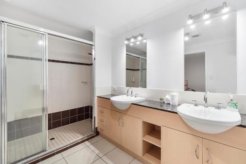 凯恩斯Spacious 3 Bedroom Townhouse in Cairns City的一间带两个盥洗盆和淋浴的浴室