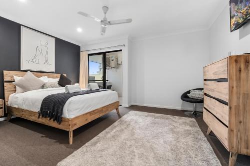 凯恩斯Spacious 3 Bedroom Townhouse in Cairns City的一间卧室配有一张床和一个梳妆台