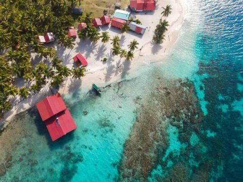 CagantupoIsla diablo cabañas en la orilla del mar baño compartido的享有热带岛屿的空中景色,设有红色房屋