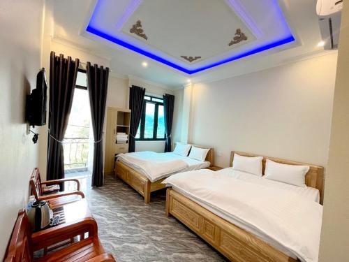 同文NHÀ NGHỈ ANH VĂN的一间卧室设有两张床和蓝色的天花板