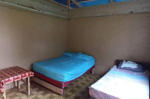 AchoertupoStay San blas islands private room的一间设有两张床和一张桌子的房间