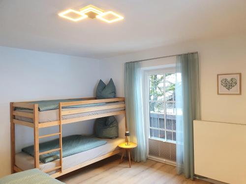 比绍夫斯维森Ferienwohnungen Winkler的一间卧室配有双层床和窗户。