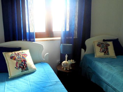 拉戈斯Casa Ameijeira的一间卧室设有两张单人床和一个窗户。