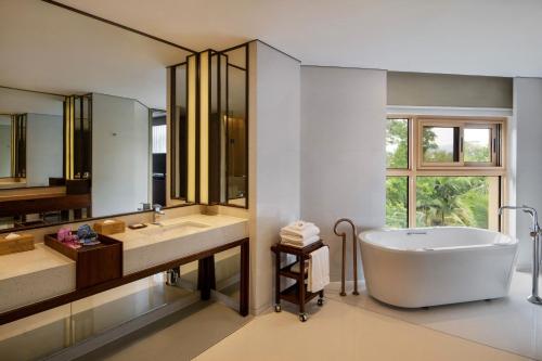 景洪市西双版纳喜来登大酒店的带浴缸、两个盥洗盆和大镜子的浴室