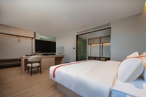 腾冲格林东方酒店(腾冲东湖公园店)的酒店客房设有一张大床和一张书桌。