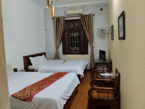 河内Holiday Home的酒店客房设有两张床和窗户。