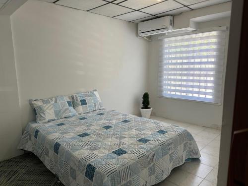 卡塔赫纳Casa Tamarielys的一间卧室配有一张带蓝色和白色棉被的床