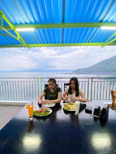 HaranggaulAgape Hotel Haranggaol的两个坐在餐桌上,配上食物盘的女人