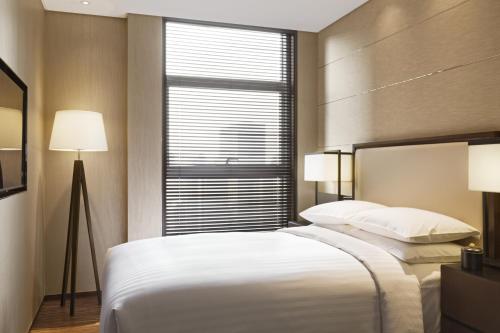 西安西安万豪行政公寓的卧室设有一张白色大床和一扇窗户。