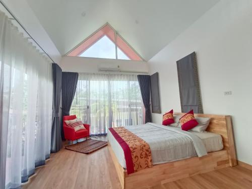 高兰อัญมัน ลันตา Anyaman Lanta的一间卧室设有一张床和一个大窗户