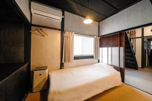 金泽HISORI Arts and Stay的一间小卧室,配有床和窗户