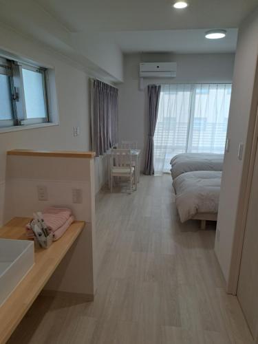 那霸Ｃｌｅａｎ　Ｈｏｔｅｌｓ　ｉｎ　Ｎａｈａ　Ｉｚｕｍｉｚａｋｉ的一间卧室配有一张床和一张书桌