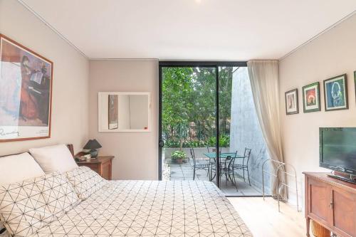 悉尼Sterling 1 Self-Catering的一间卧室配有一张床、一台电视和一个庭院。