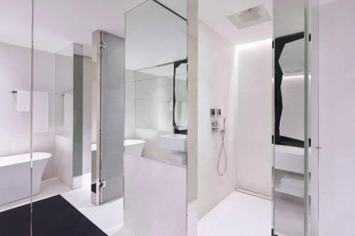 新加坡JW Marriott Hotel Singapore South Beach的带淋浴和盥洗盆的白色浴室