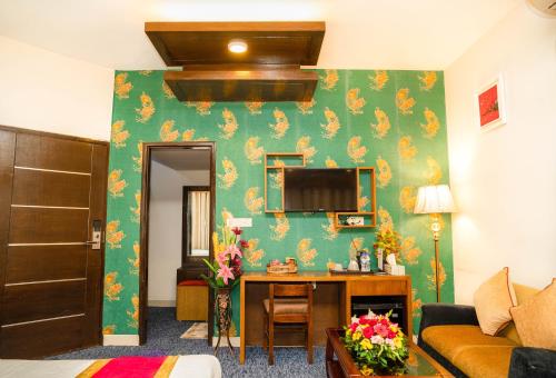 达卡Hotel Air Inn Ltd - Airport View的客厅设有绿色墙壁和书桌