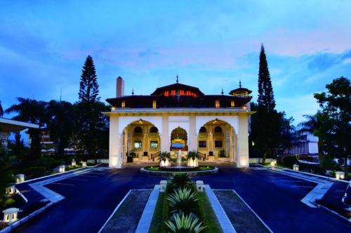 武吉丁宜TripleTree Hotel And Resort Bukittinggi的前方设有庭院的大型建筑