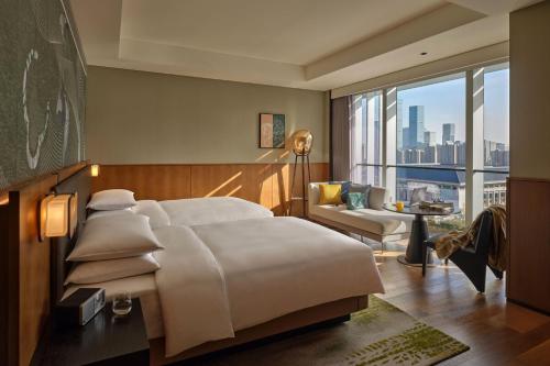 西安西安高新凯悦尚萃酒店的一间卧室设有一张大床和一个大窗户