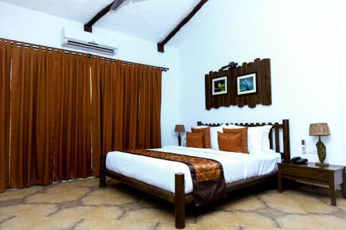 KotaAnaya Resort的一间卧室配有一张带棕色窗帘的大床